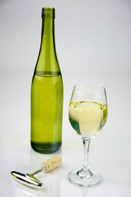 Una bottiglia e un bicchiere di vino bianco